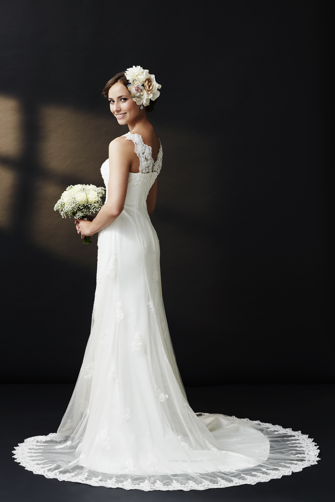 Glamorous young bride in wedding dress, smiling.